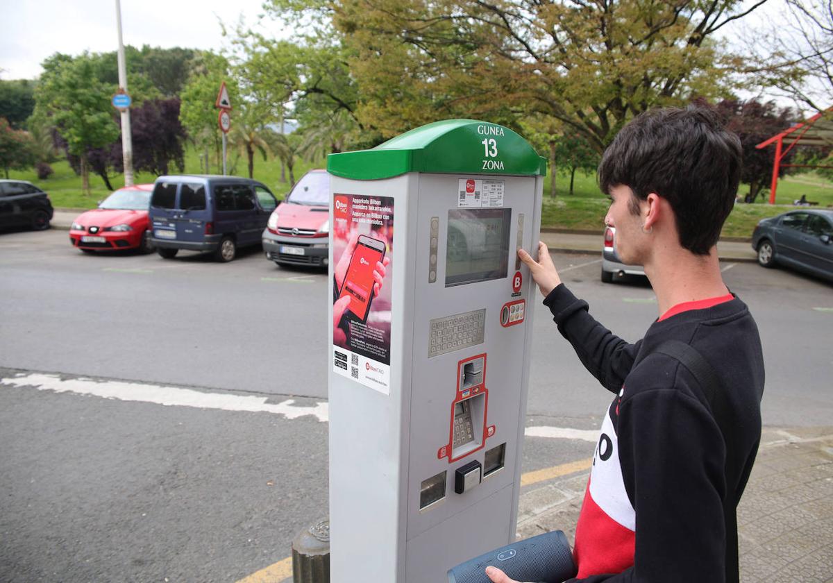 Una persona usando un parquímetro en la Peña, en Bilbao.