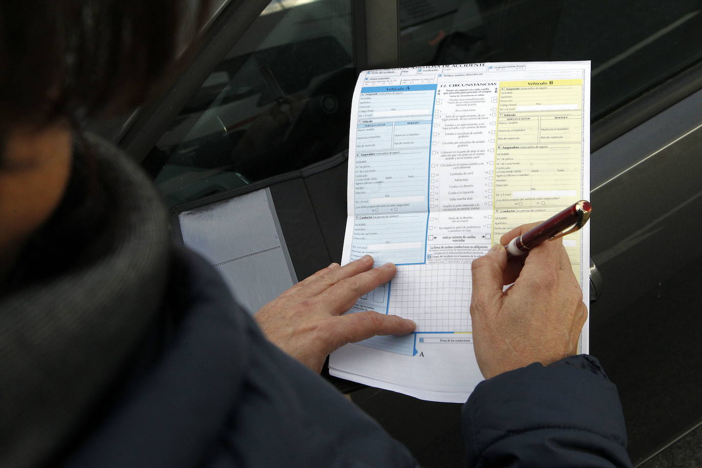 Firma de un parte amistoso de seguros de coche.