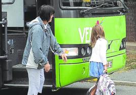 Una niña baja del autobús escolar para acudir a su ikastola.