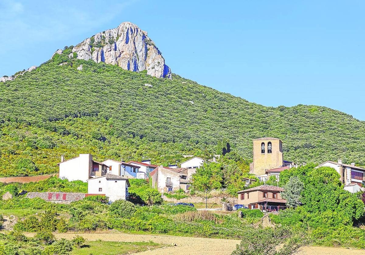 Naturaleza y arte. El caserío resguardado bajo Peña Unzué. A la derecha, pinturas murales cubren la cabecera de Santa María de Eristain.