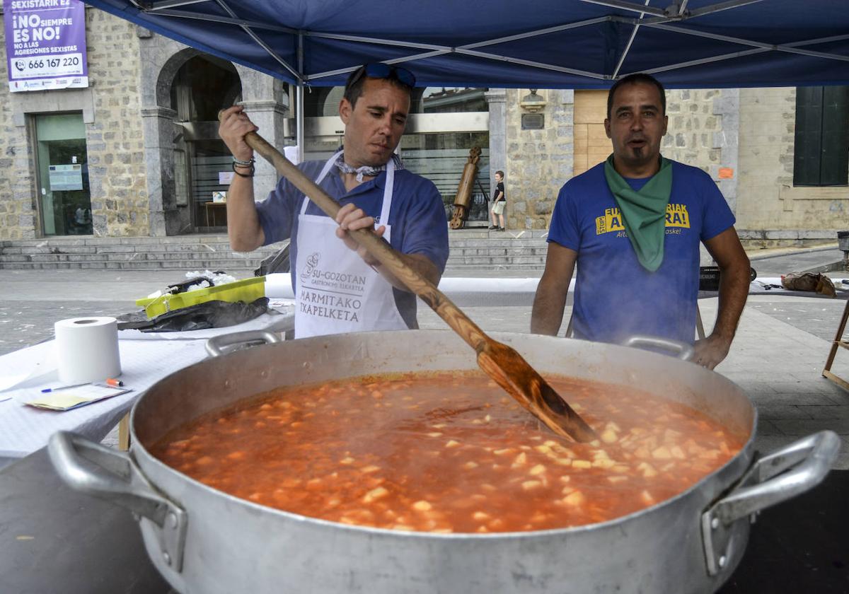 Dos integrantes de Su Gozotan preparan la degustación de marmitako con la que repartieron 250 raciones en la plaza.