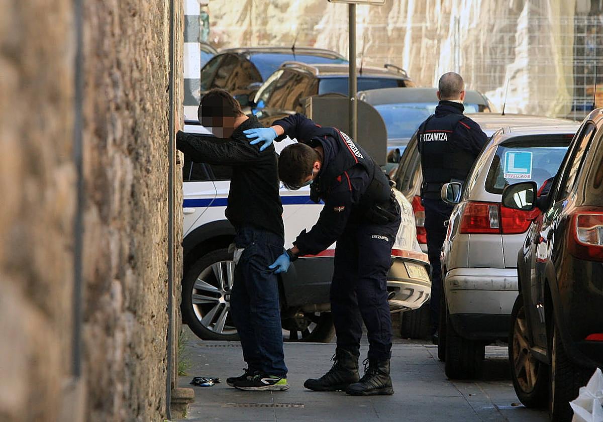 Patrulleros de la Ertzaintza registran a un joven en una calle de Vitoria.