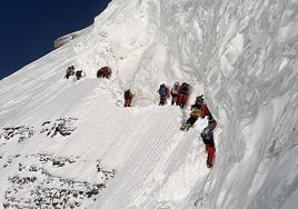 Garraiolariaren gorputza bidean etzanda dago, alpinistak gelditu gabe haren ondotik pasatzen diren bitartean.