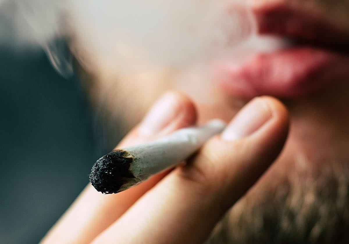 Una persona fuma un porro.