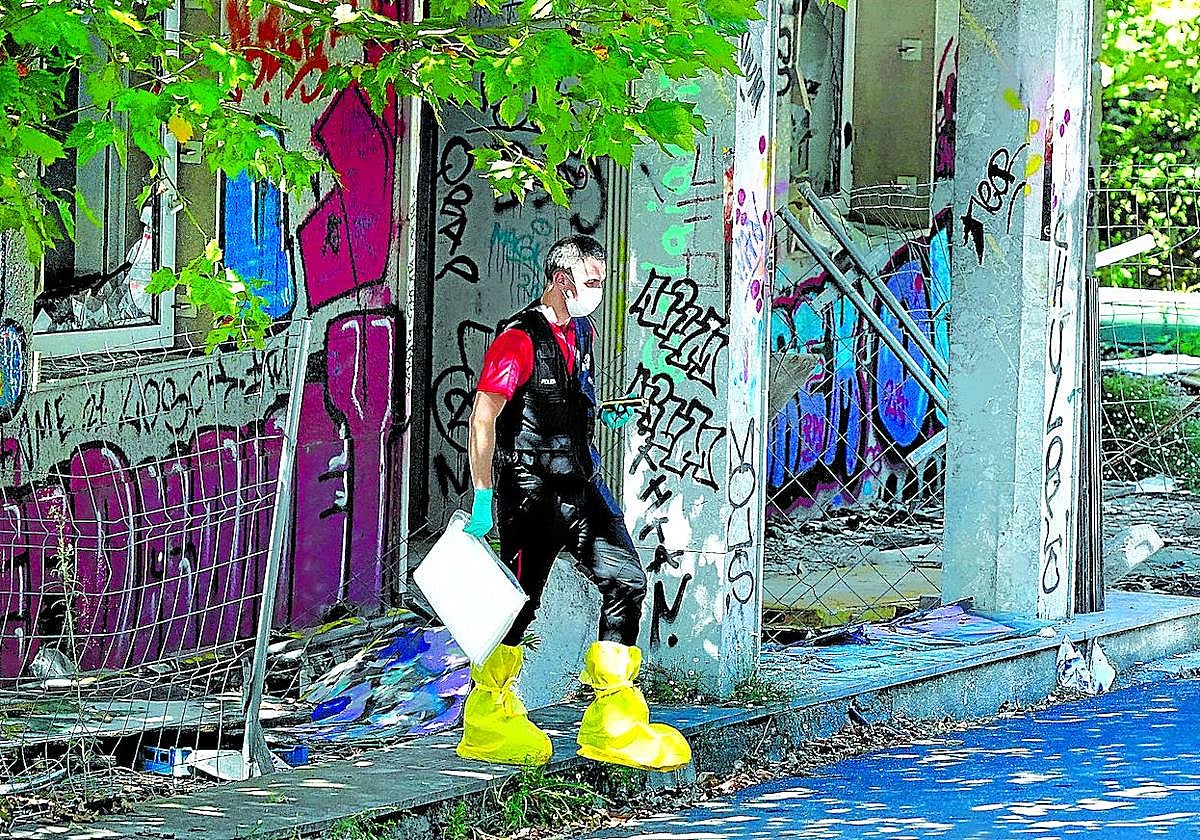 Un investigador policial sale del edificio abandonado de Artxanda en el que fue hallada la maleta en la que apareció el cuerpo.