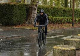 Un ciclista circula por Vitoria bajo la lluvia.