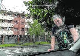 Un vecino de Igorre contempla el estado en el que quedó la luna de su coche tras la lluvia y el granizo del pasado lunes.