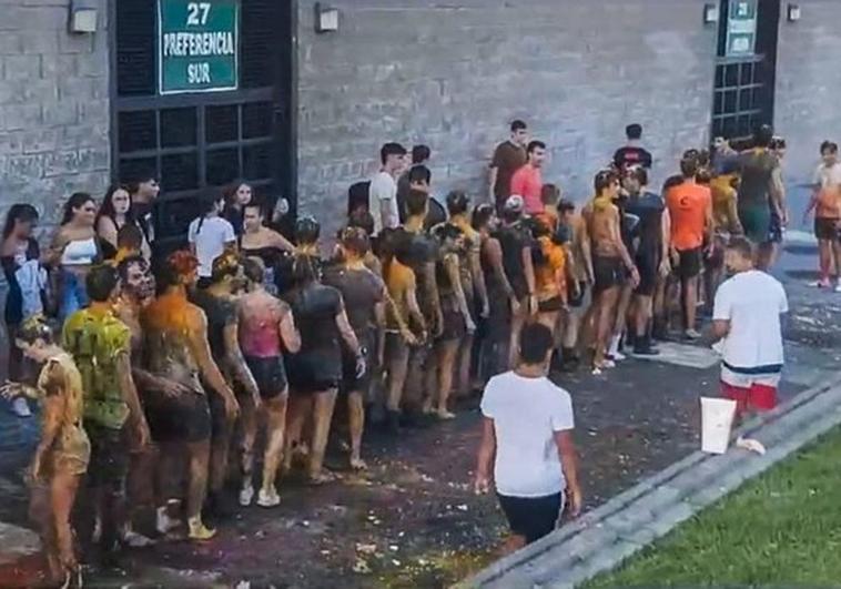 Los estudiantes de primer curso, en fila india, empapados y manchados, a las órdenes de los veteranos, el pasado miércoles, en El Sardinero.