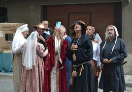 Un grupo de participantes en la feria medieval de Artziniega disfrutan con la decoración de la iglesia.