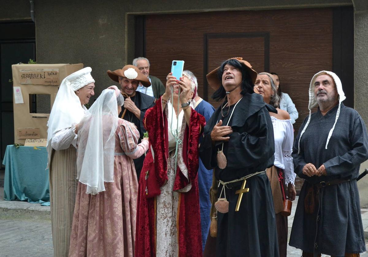 Un grupo de participantes en la feria medieval de Artziniega disfrutan con la decoración de la iglesia.