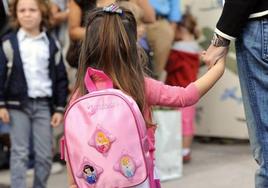 Una niña entra en el cole el primer día del curso.