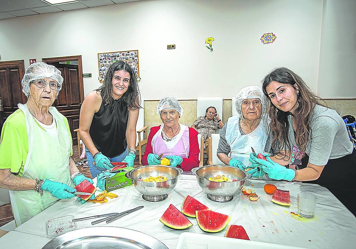Actividad. Varias usuarias y trabajadoras preparan brochetas de frutas en la residencia.