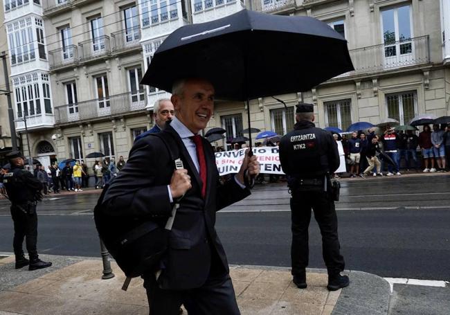 Josu Erkoreka camina frente a los agentes concentrados antes de acceder al Parlamento vasco.