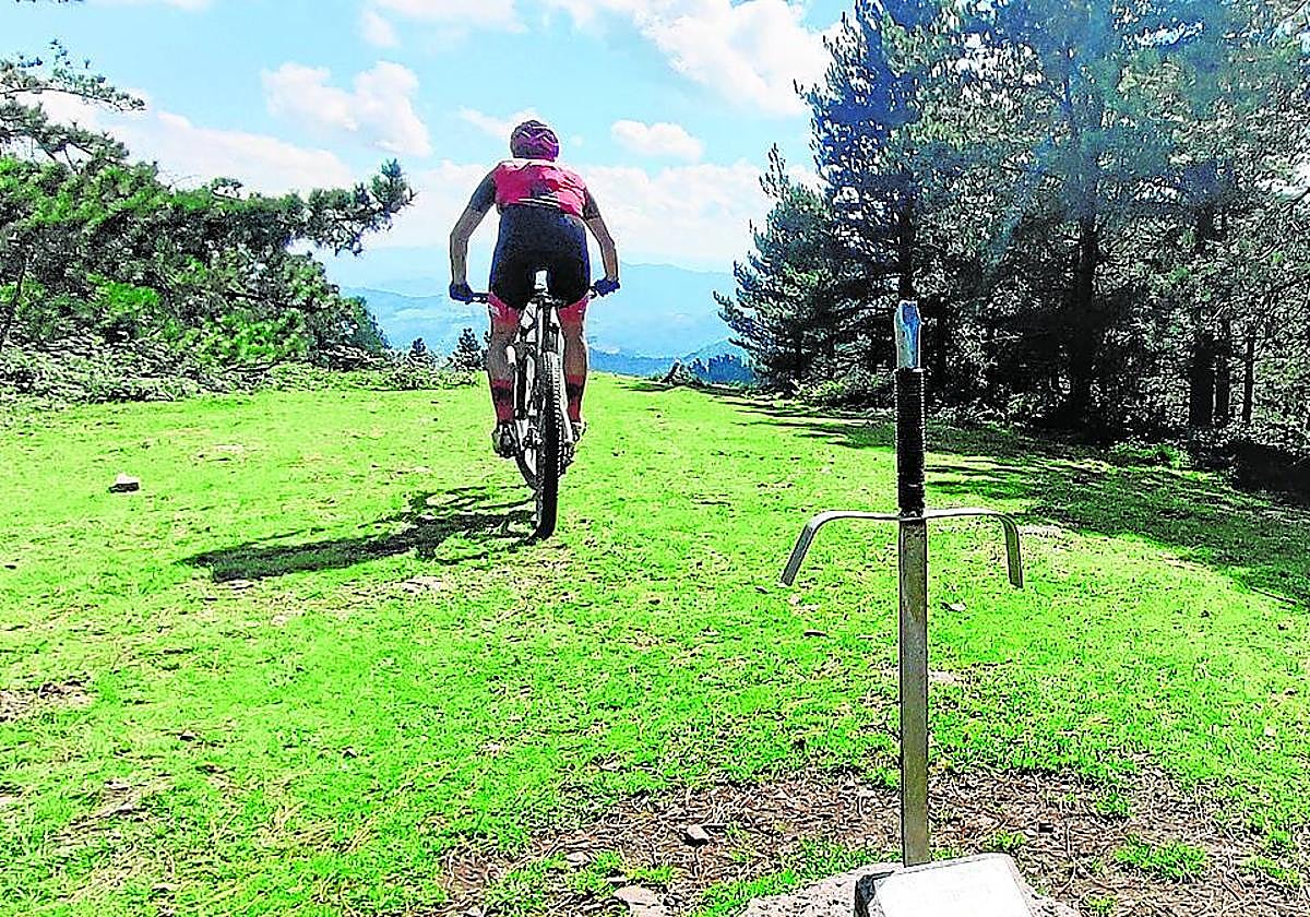 Un ciclista pasa junto a la espada, con vistas a los montes del Gran Bilbao.