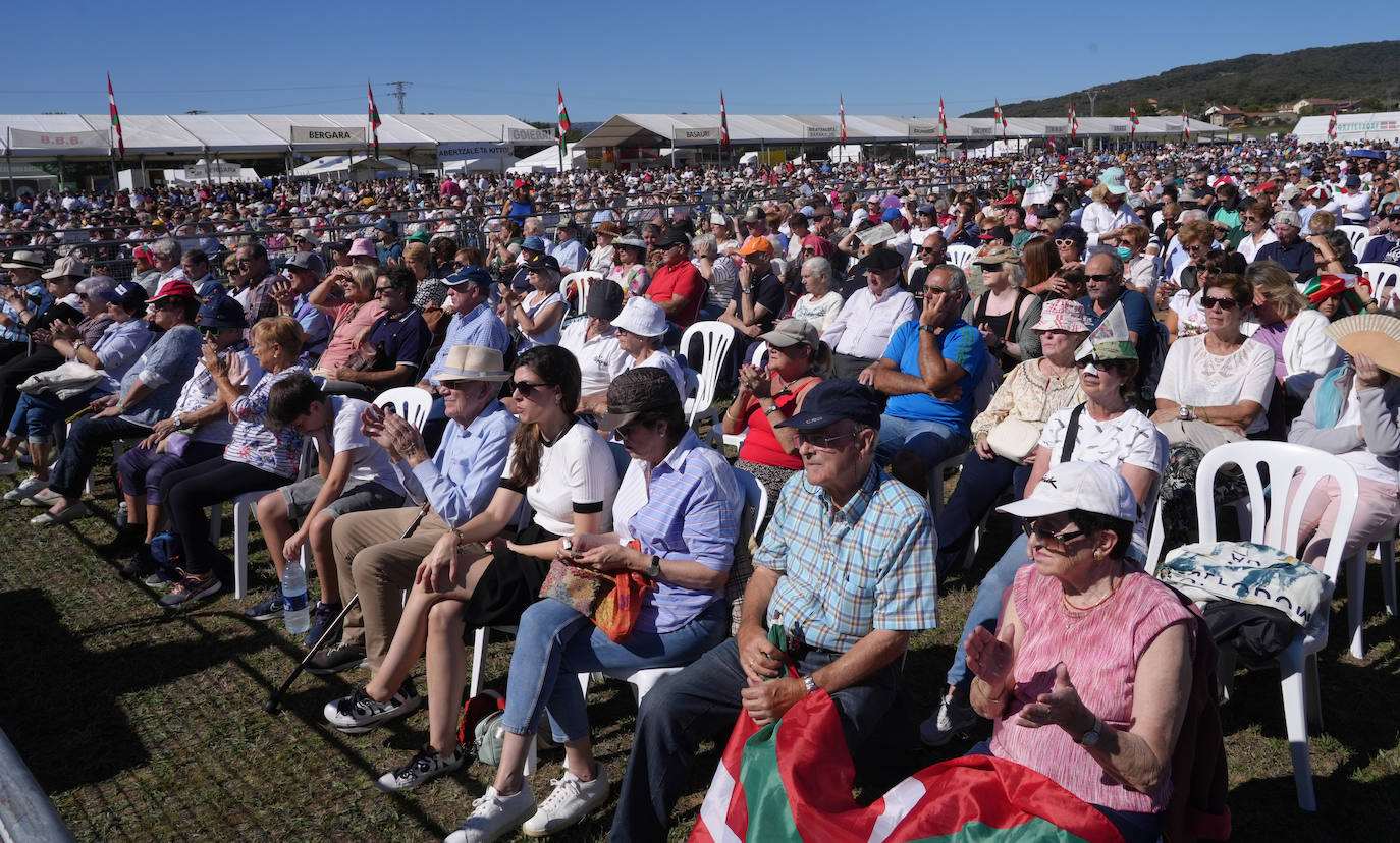 Asistentes al acto atentos a los discursos, bajo el sol