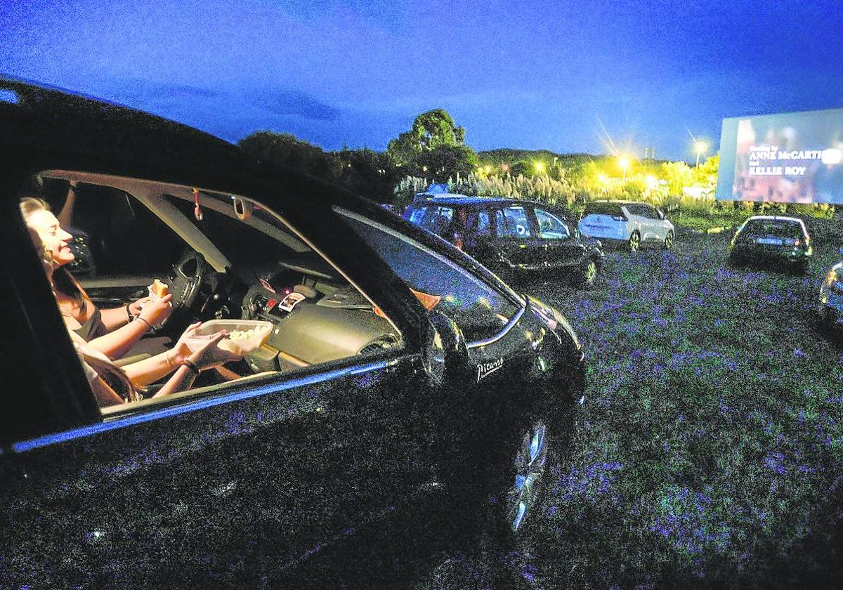 Dos personas siguen una de las sesiones desde su coche al atardecer.