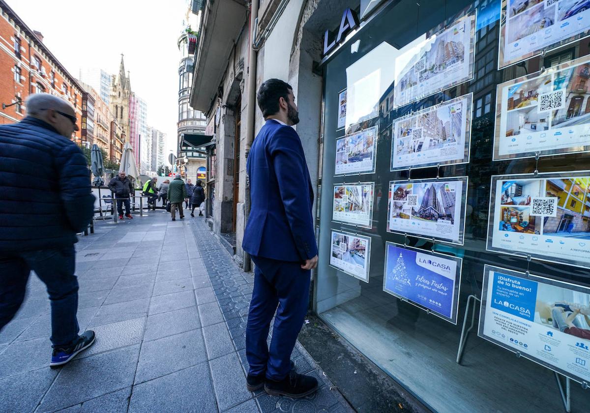 Un ciudadano observa el escaparate de una inmobiliaria en Bilbao.