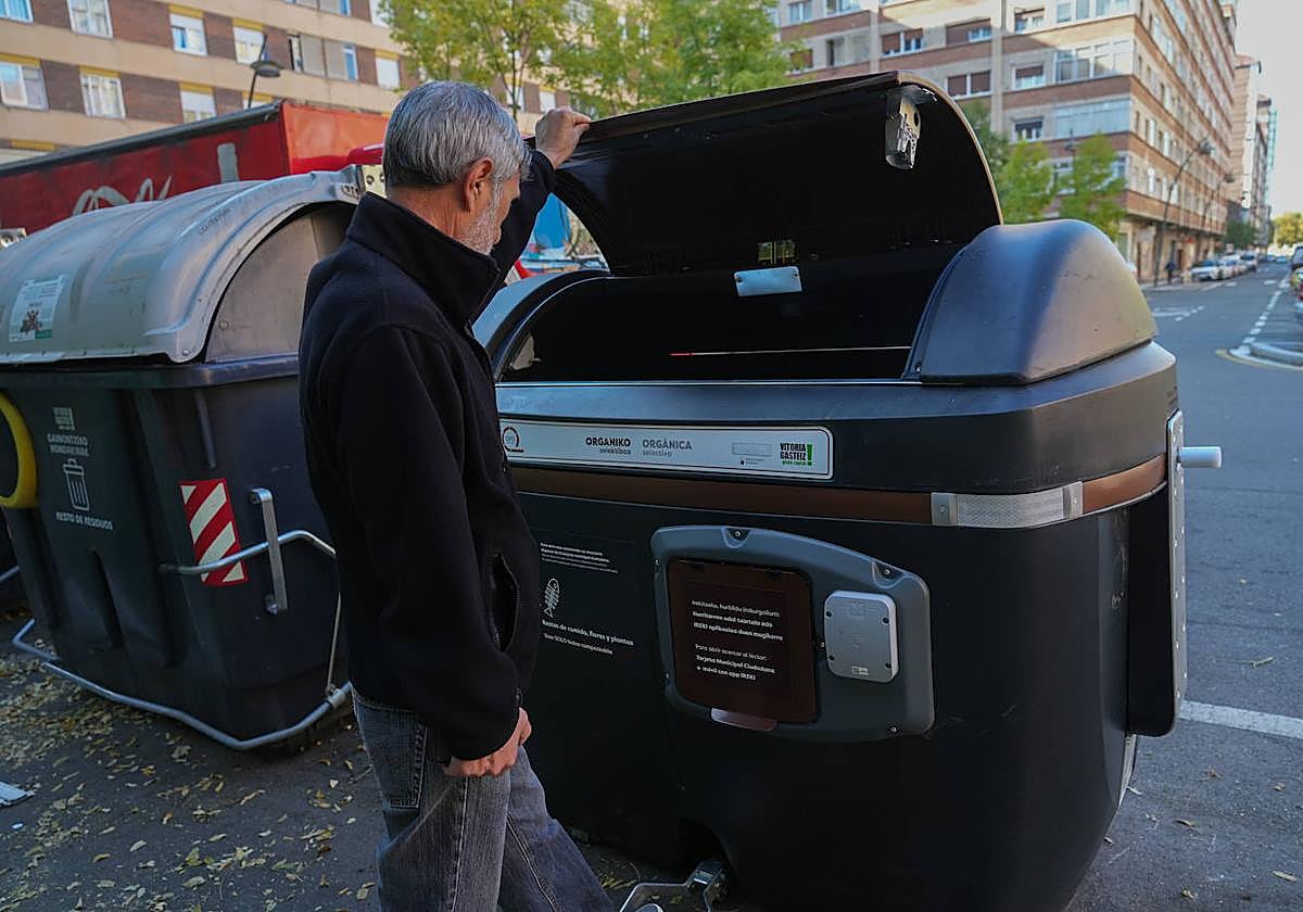 Un hombre deposita la basura en un cotenedor 'marrón' en el barrio de Lakua.