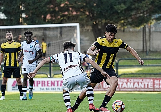 Josu Juste trata de zafarse de Marcos Martínez.