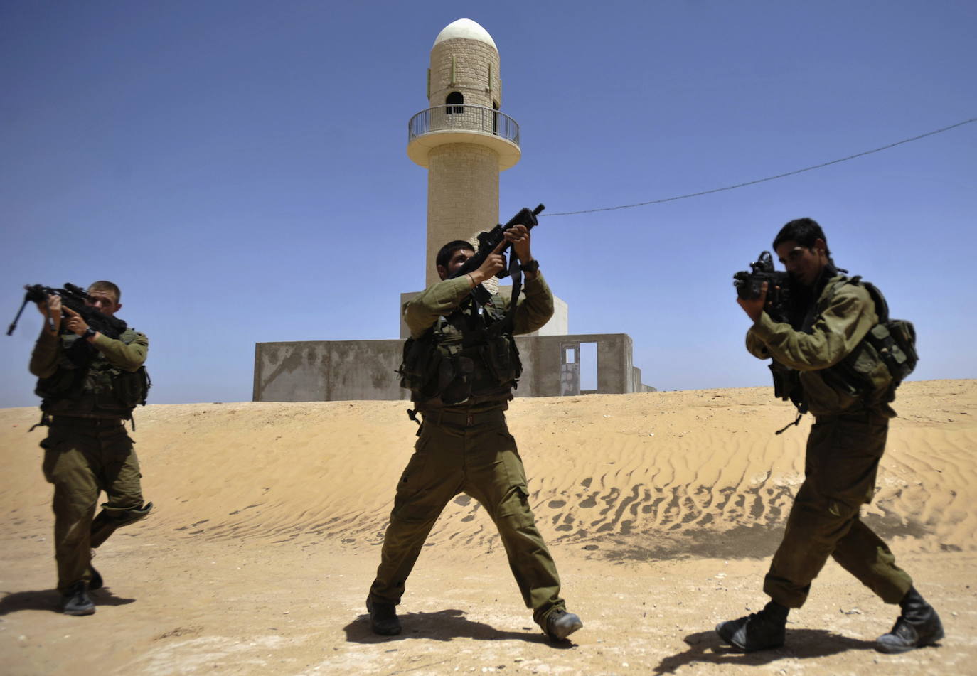 Imagen principal - Arriba, el campo de Tzeelim, donde Israel se entrena para entrar en Gaza. Abajo, un tanque Merkava y un miembro de Hamás excavando un túne.