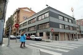 Una persona cruza un paso de cebra junto al Ayuntamiento.