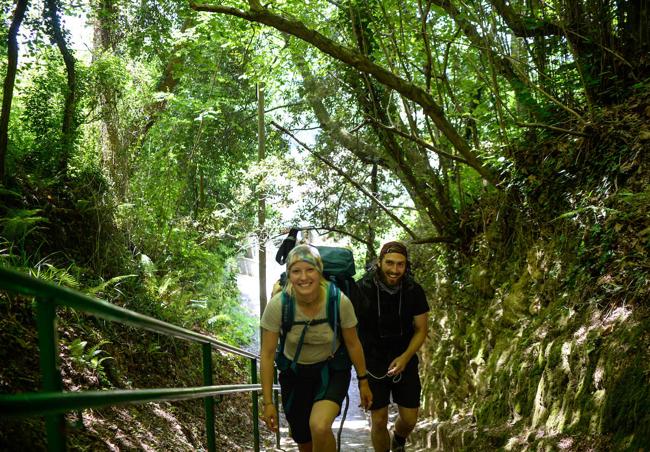 Dos peregrinos ascienden escaleras en Pobeña.