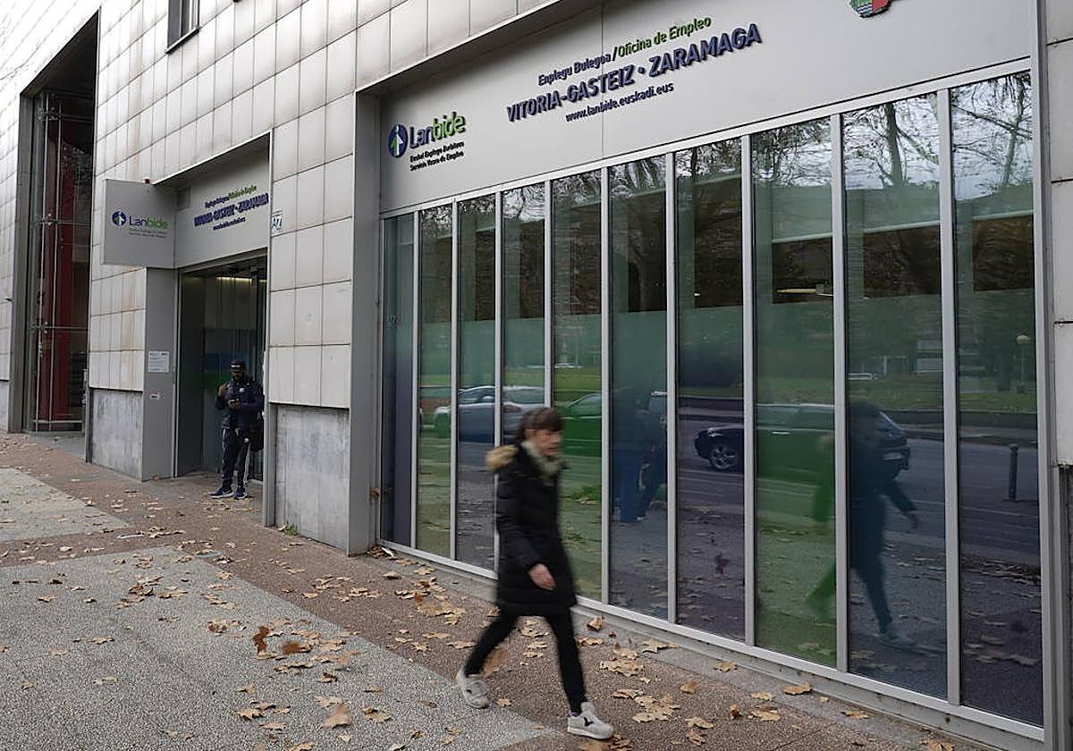Una joven ajena a la noticia pasa frente a unaoficina de Lanbide en Vitoria.