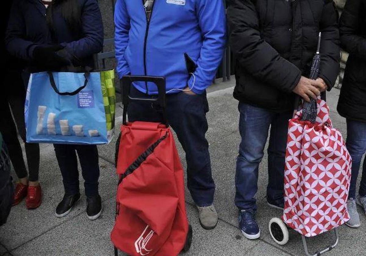 Varias personas esperan para recibir ayuda.