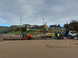 Operarios desmantelan los últimos restos de ladrillos.