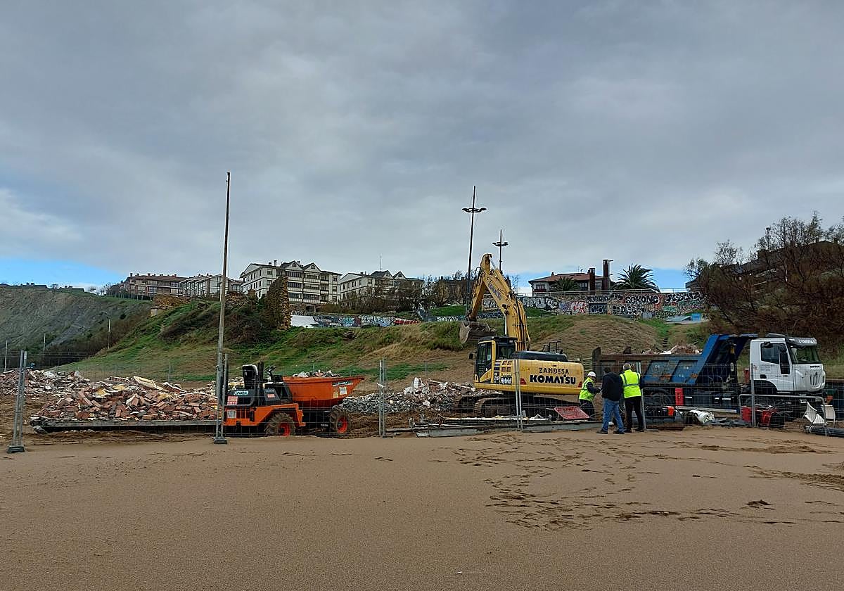 Operarios desmantelan los últimos restos de ladrillos.