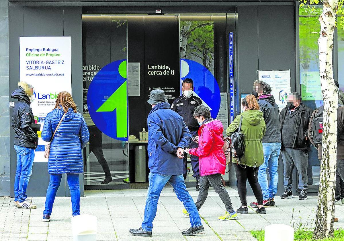 Varias personas esperan en el exterior de una oficina de Lanbide en Vitoria.