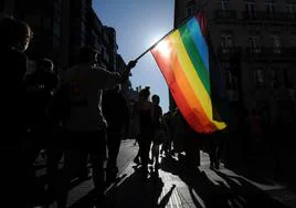 Un grupo de personas despliega una bandera arcoíris en Vitoria.