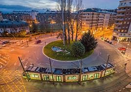 El tranvía circula al amanecer por la plaza Lovaina de Vitoria.