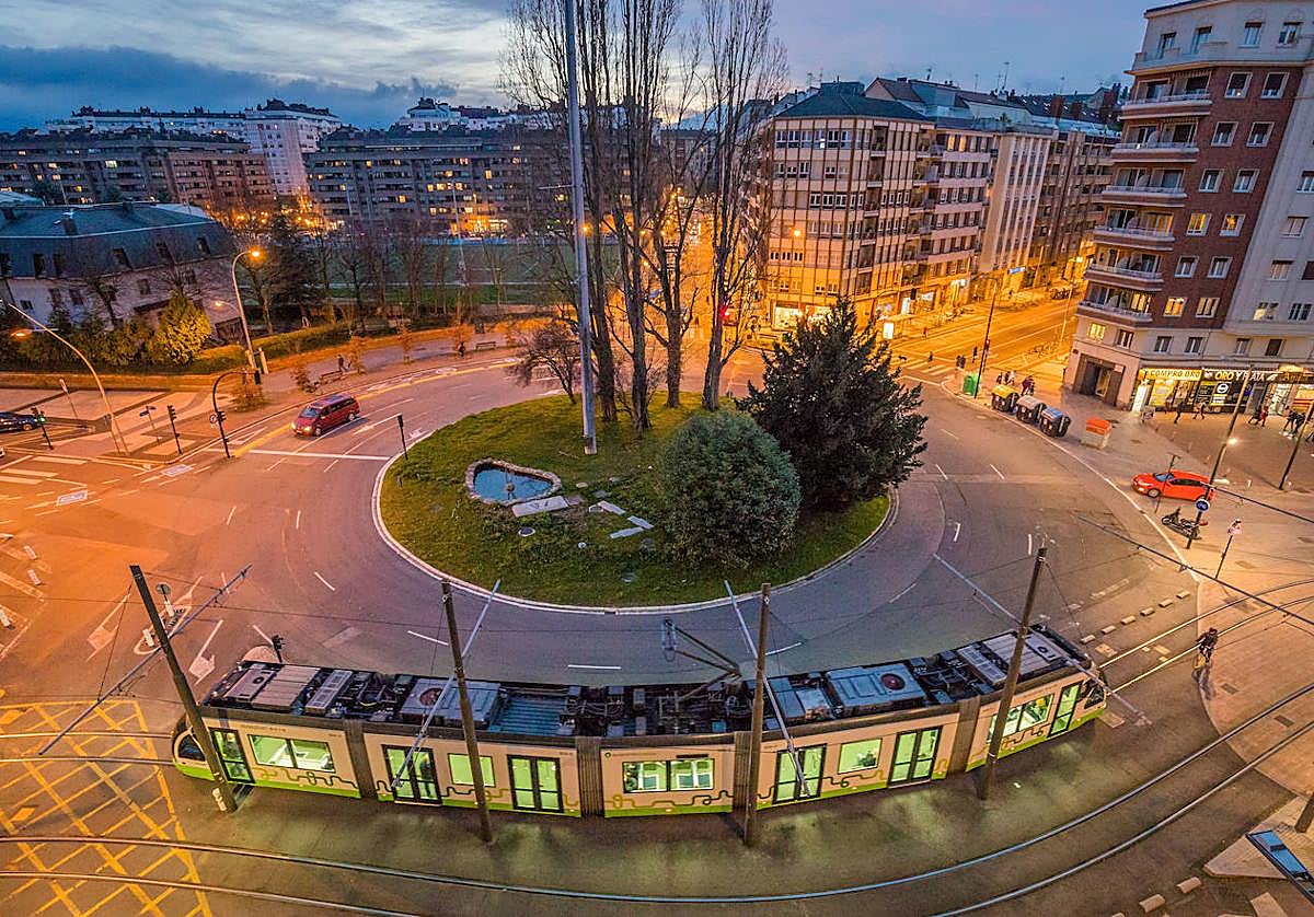 El tranvía circula al amanecer por la plaza Lovaina de Vitoria.