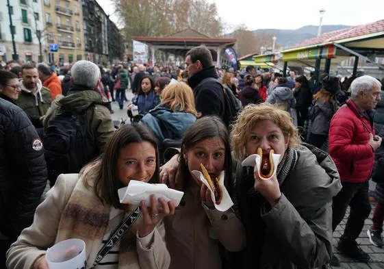 Tres asistentes a la feria no se han resistido a degustar el típico talo con chorizo, que se puede comprar por entre 6,50 y 7 euros.