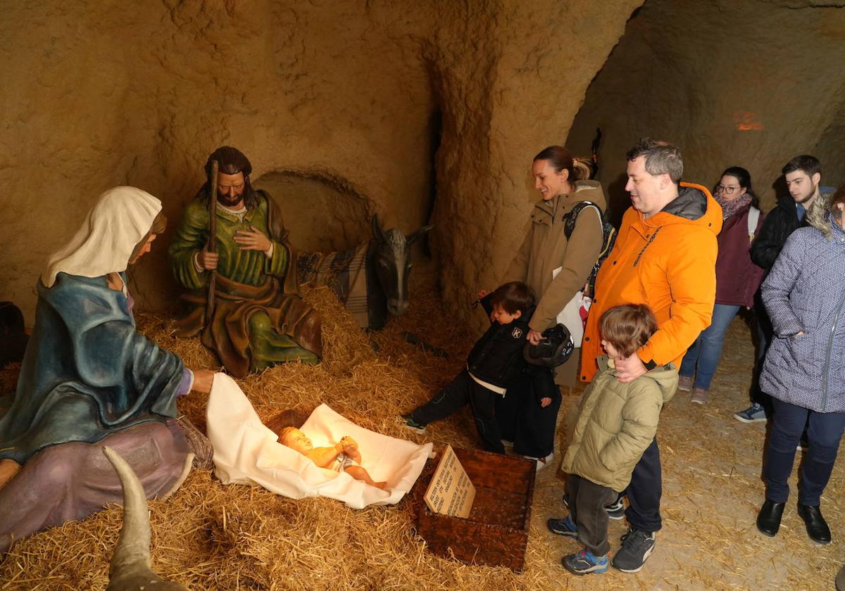 Un grupo de visitantes contempla a la Sagrada Familia en la gruta del parque de La Florida.