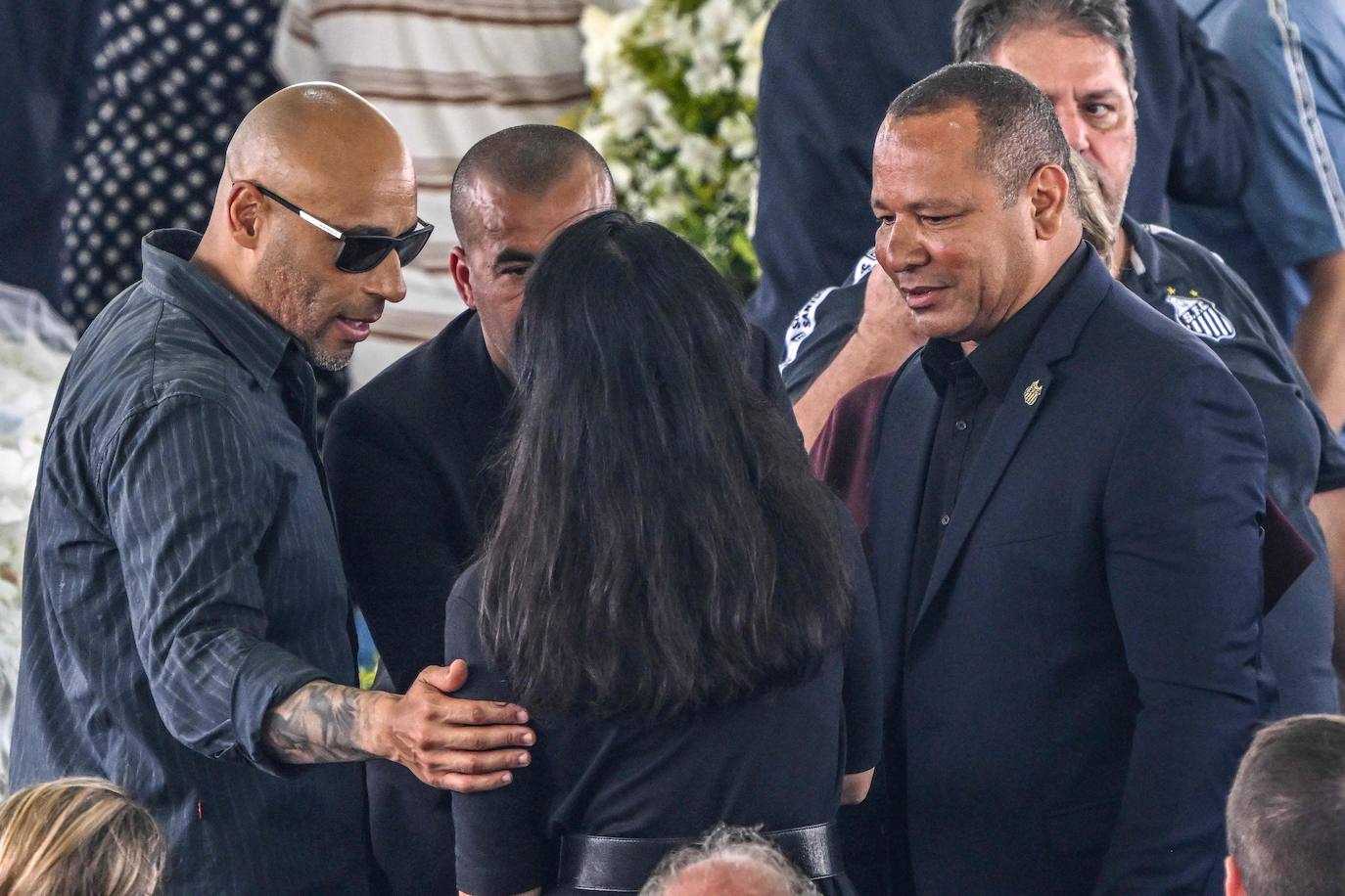 La esposa de Pelé, Marcia Aoki (centro), conversa con el hijo de Pelé, Edinho (izquierda) y el padre de Neymar (derecha), durante el velorio del mito.