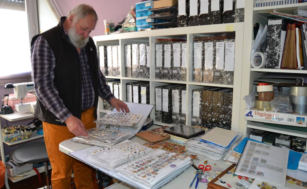 Arto consulta su colección de pines almacenada en una treintena de carpetas clasificadoras. 