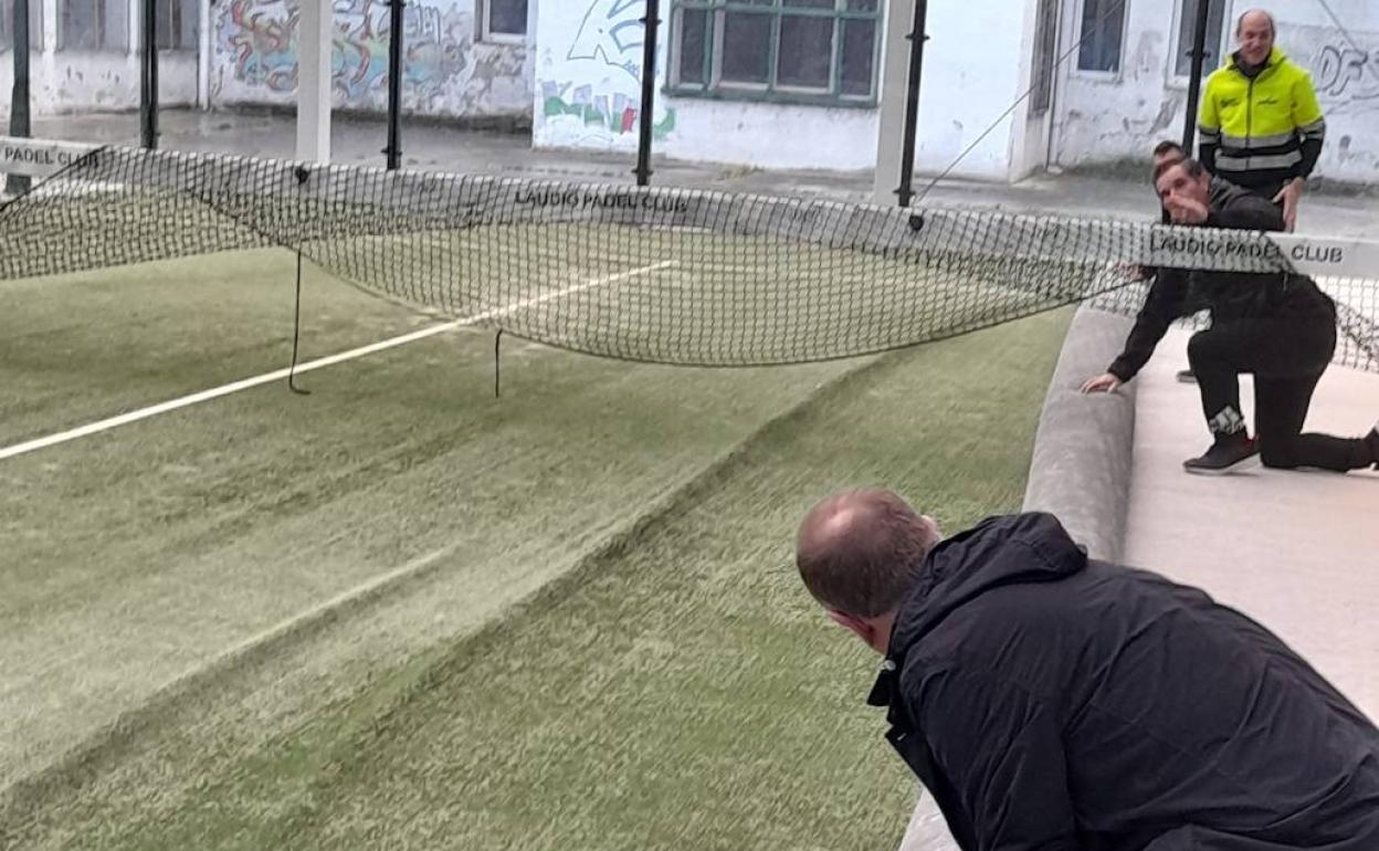 Los aficionados recogen la pista para quitar los pliegues. 