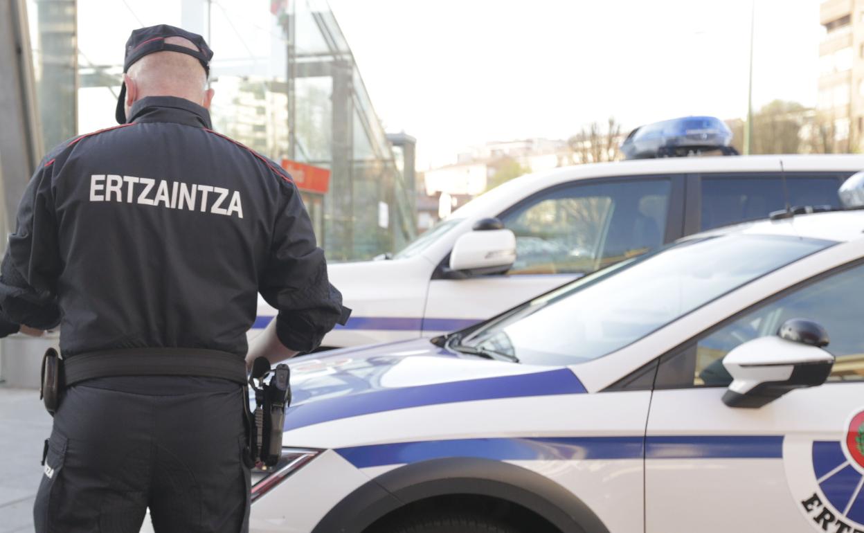 Un agente de la Ertzaintza junto al coche patrulla en Getxo. 
