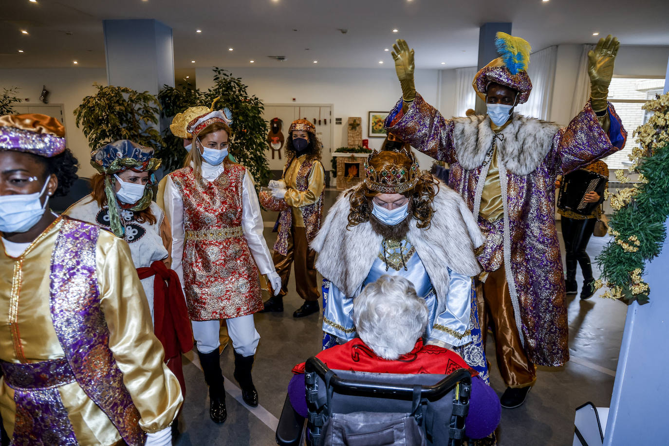Melchor y Baltasar, acompañados de parte de su séquito, saludan a una de las ancianas de la residencia Txagorritxu. 