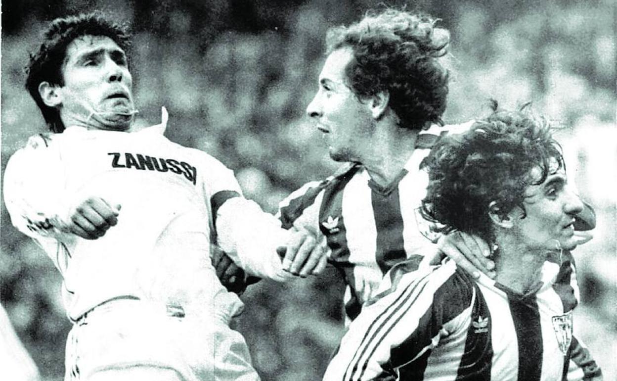 Santillana salta para rematar un balón incomodado por Liceranzu y Noriega. 