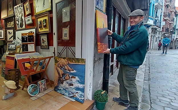 Joseba Elorriaga cuelga una de sus creaciones a la entrada de su negocio en al calle Erremedio. 