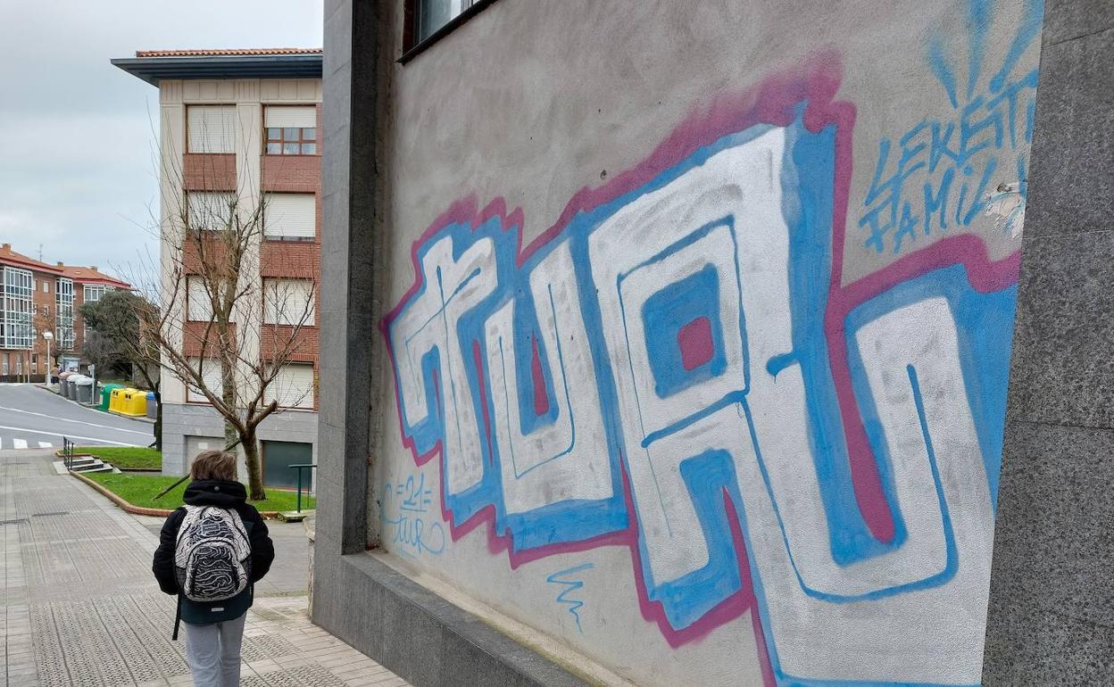 Un niño pasa por delante de un grafiti de Lekeitio. 
