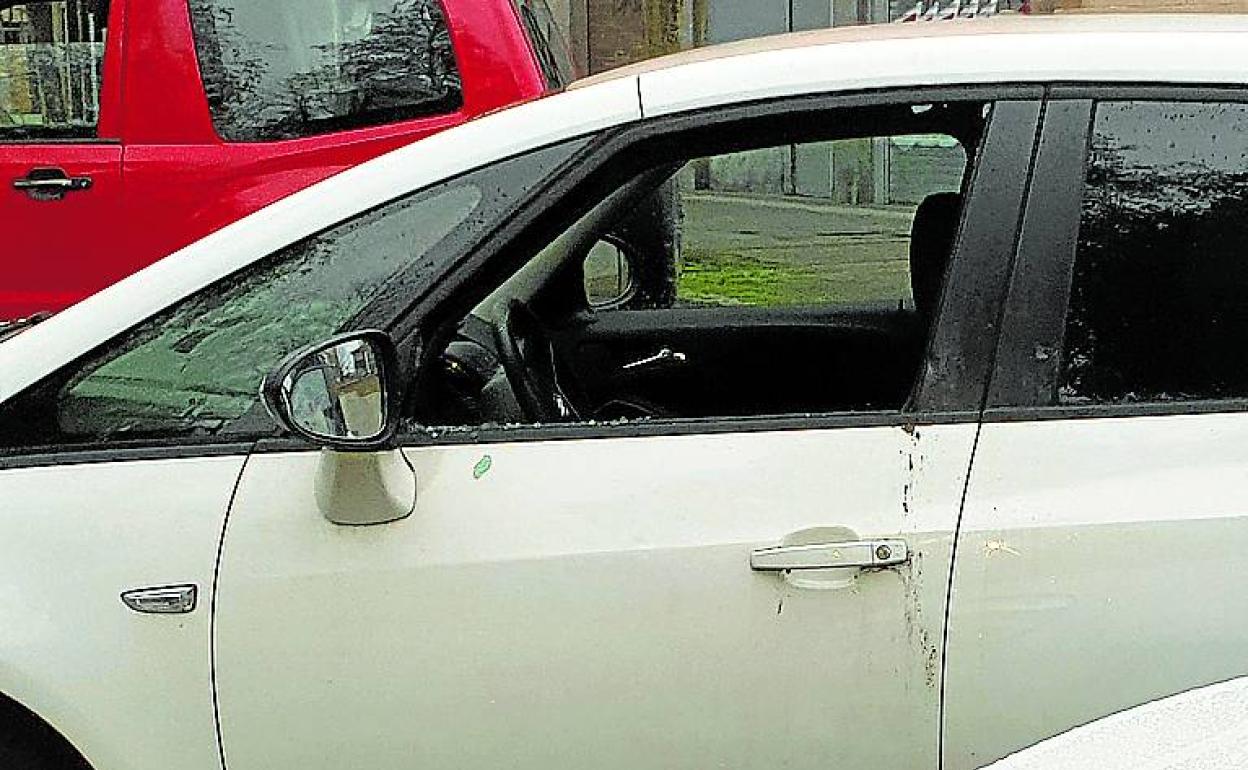 Imagen de uno de los coches atacados, con la ventanilla rota