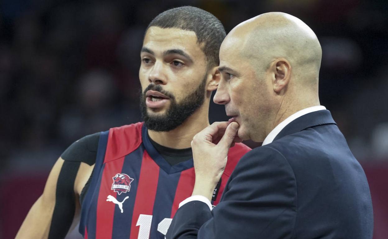 Peñarroya se muestra pensativo durante una acción del partido, con Darius Thompson a su lado. / 