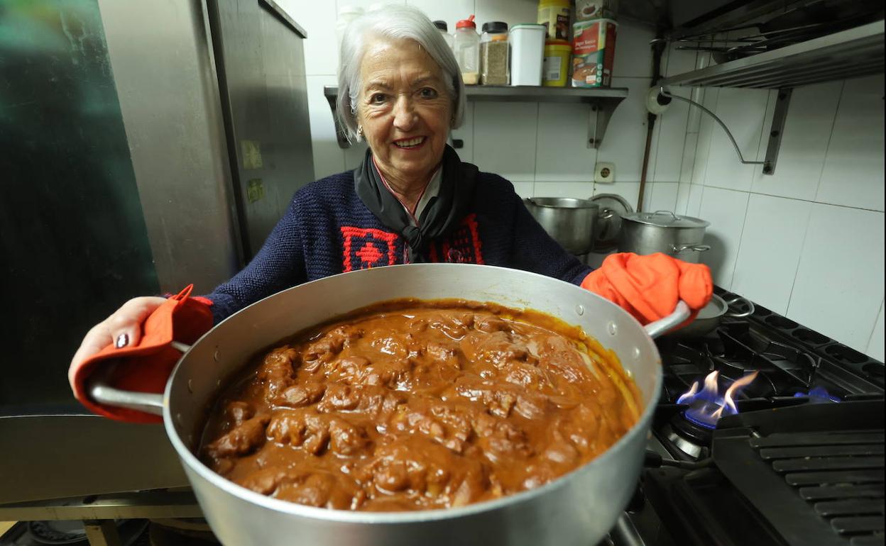 La guisandera Inma Landeta muestra una cazuela de patas de cerdo. 