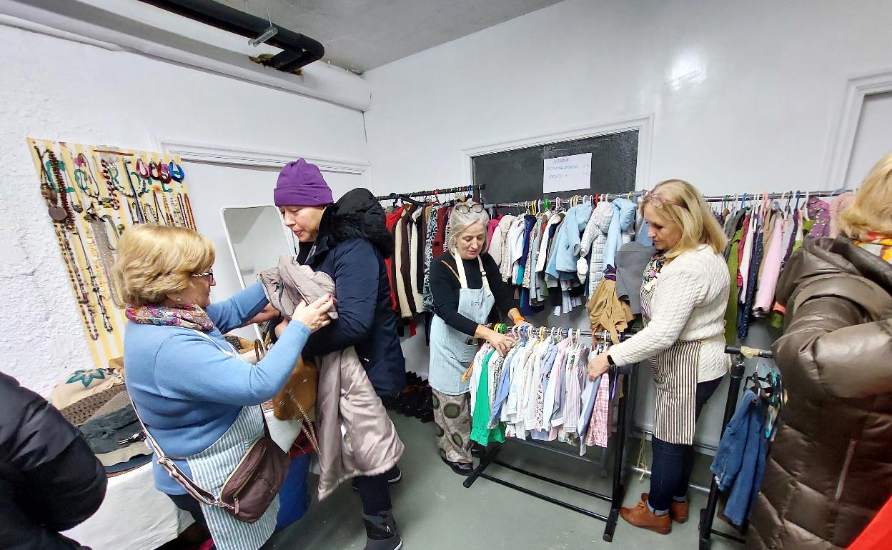 Gaztañaga, a la izquierda de la foto, charla con una vecina interesada en comprar una prenda en el outlet. 