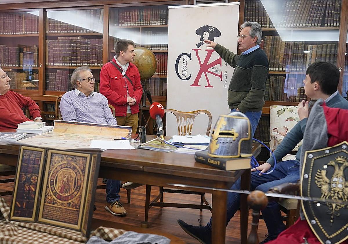 Ramón Jiménez, junto a miembros de la Asociación Histórica Vitoria 2013, señala el rostro de Carlos V en el cartel del 500 aniversario de la estancia del emperador en Vitoria.
