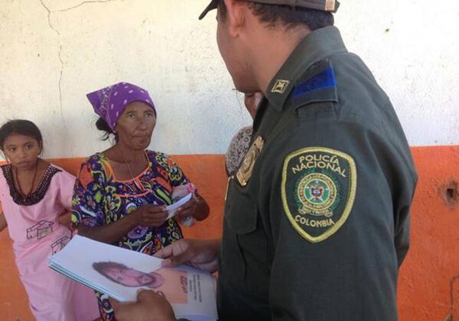 Un policía colombiano enseña a dos mujeres una imagen de Borja Lázaro.